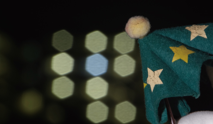 [photo] Green, cloth umbrella in foreground with blurred hexagonal lights in background