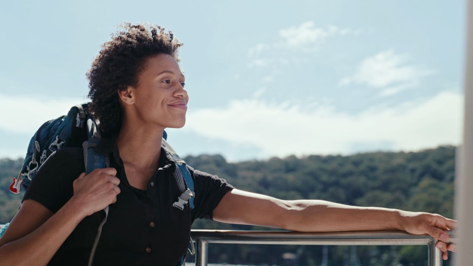 'A woman on a boat looking ahead with a smile.'