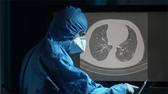 Man in surgical gown and CT image