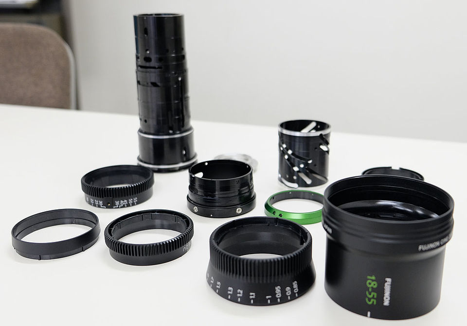 [photo] A disassembled Fujinon 18-55m lens including the focus, zoom, iris parts on a table