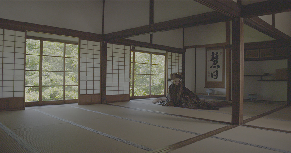 [photo] A less saturated photo of a lady dressed in a Japanese attire sitting on the floor Japanese temple