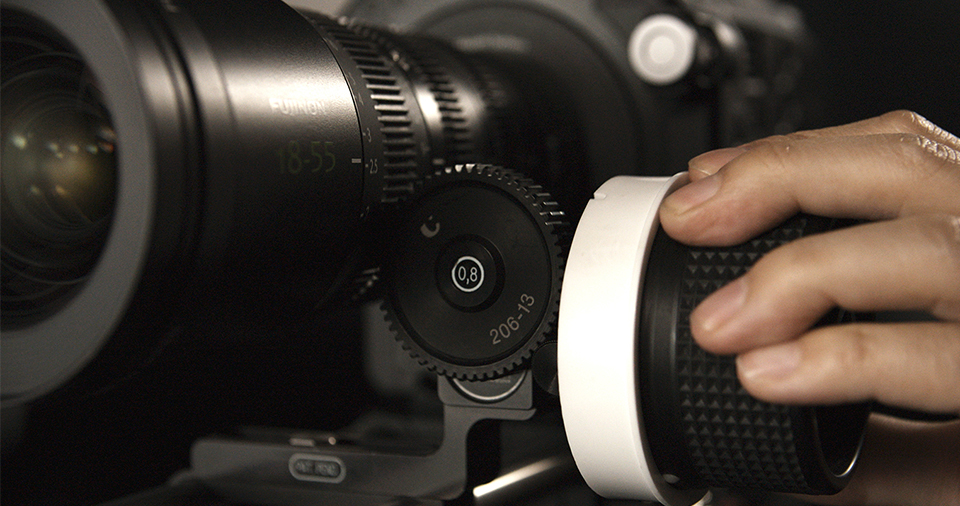 [photo] A cameraman's had on a follow-focus wheel attached to an MK Series lens