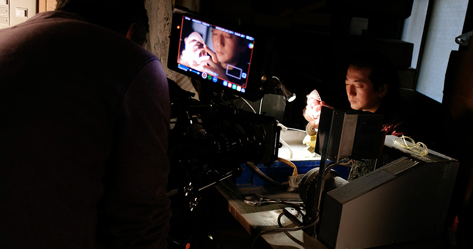 [photo] A cameraman shooting a subject working under a lamp