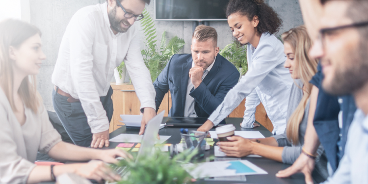 Employees gathered around a board room table