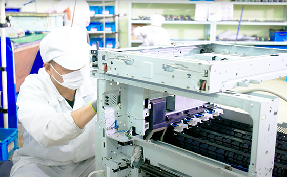 Workers checking a dismantled multifunction machine.