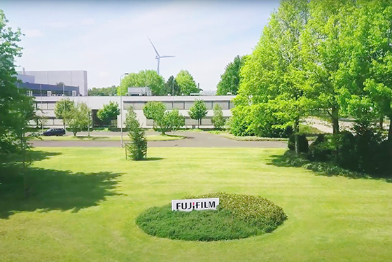 There is a Fujifilm sign in the middle of the lawn. Entrance to the factory.