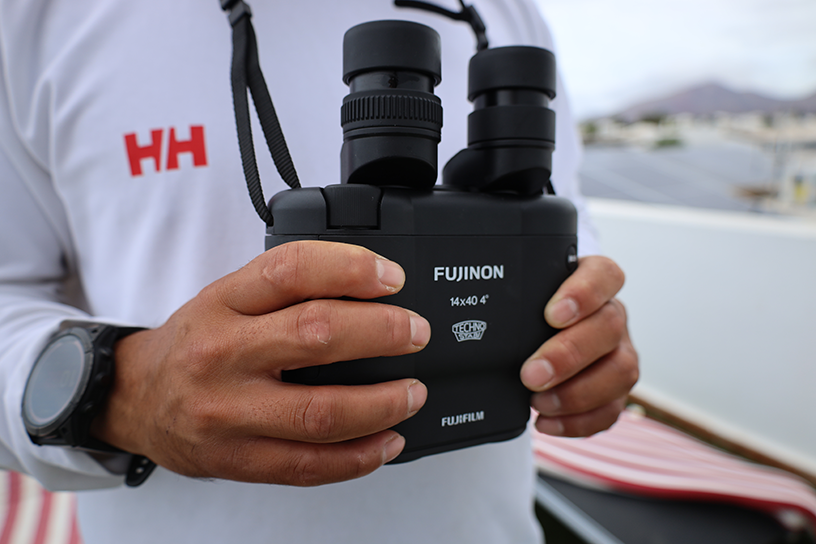 A close-up of hands holding binoculars.